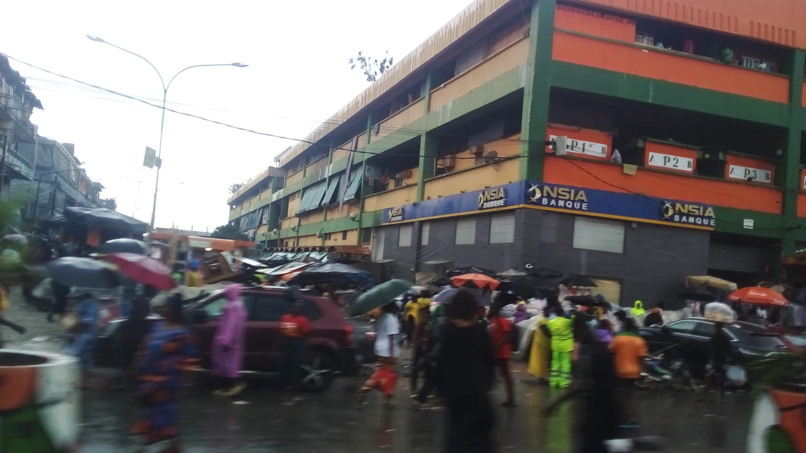 Passants et circulation devant le marché Forum d’Adjamé, à Abidjan, en 2024.