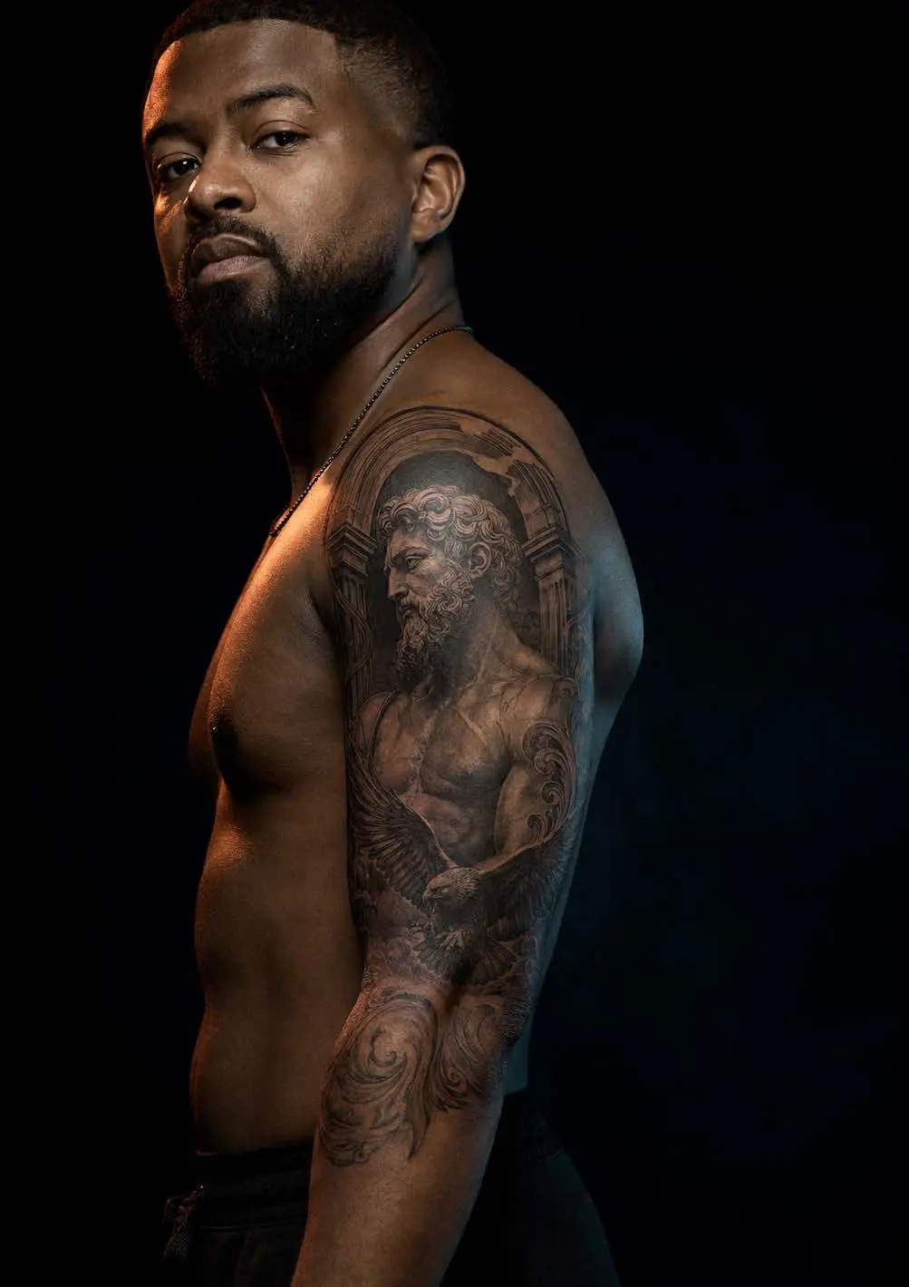 Portrait d’un homme portant une grande pièce tatouée en noir et gris